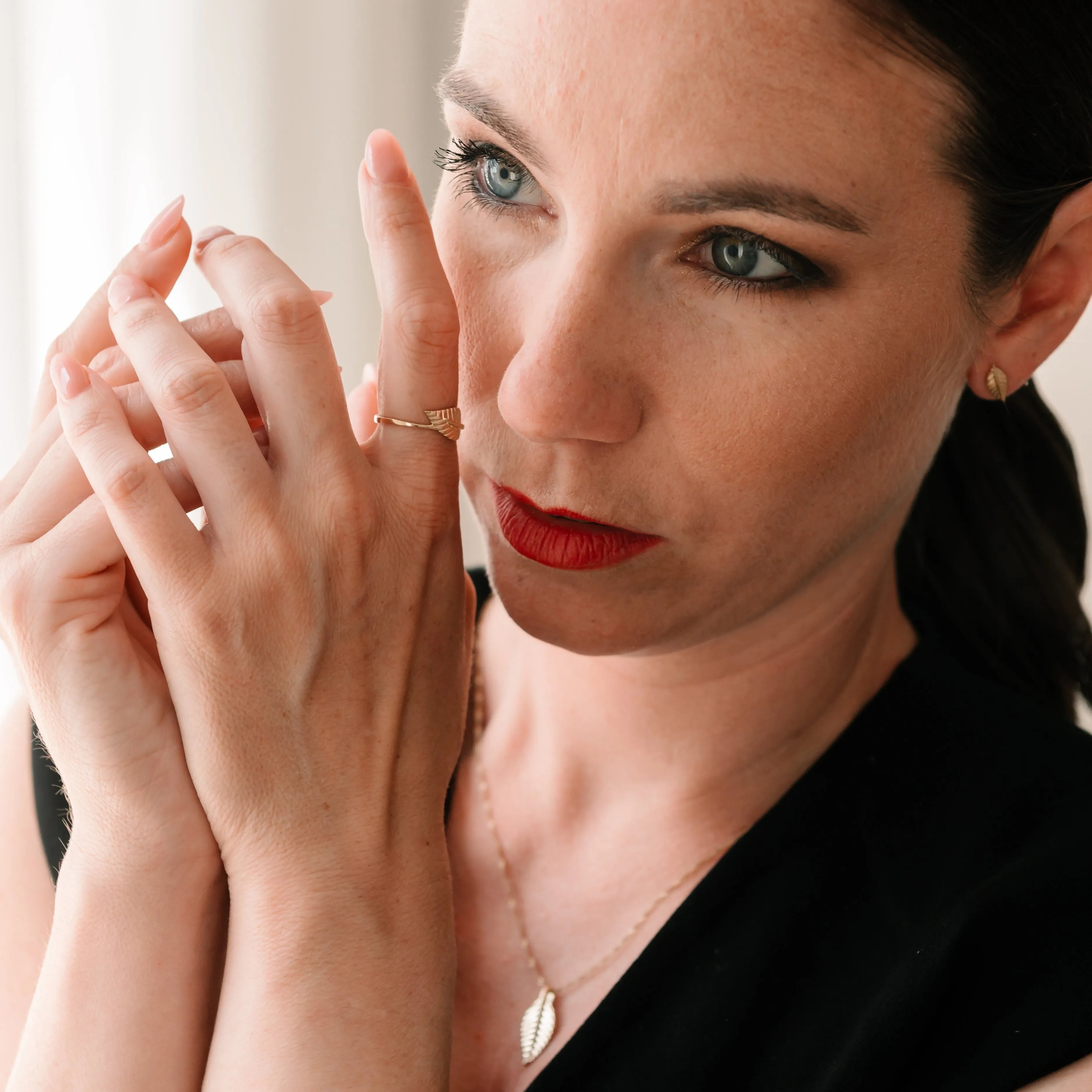 Elegantná žena so zlatým prsteňom a náhrdelníkom v tvare listu