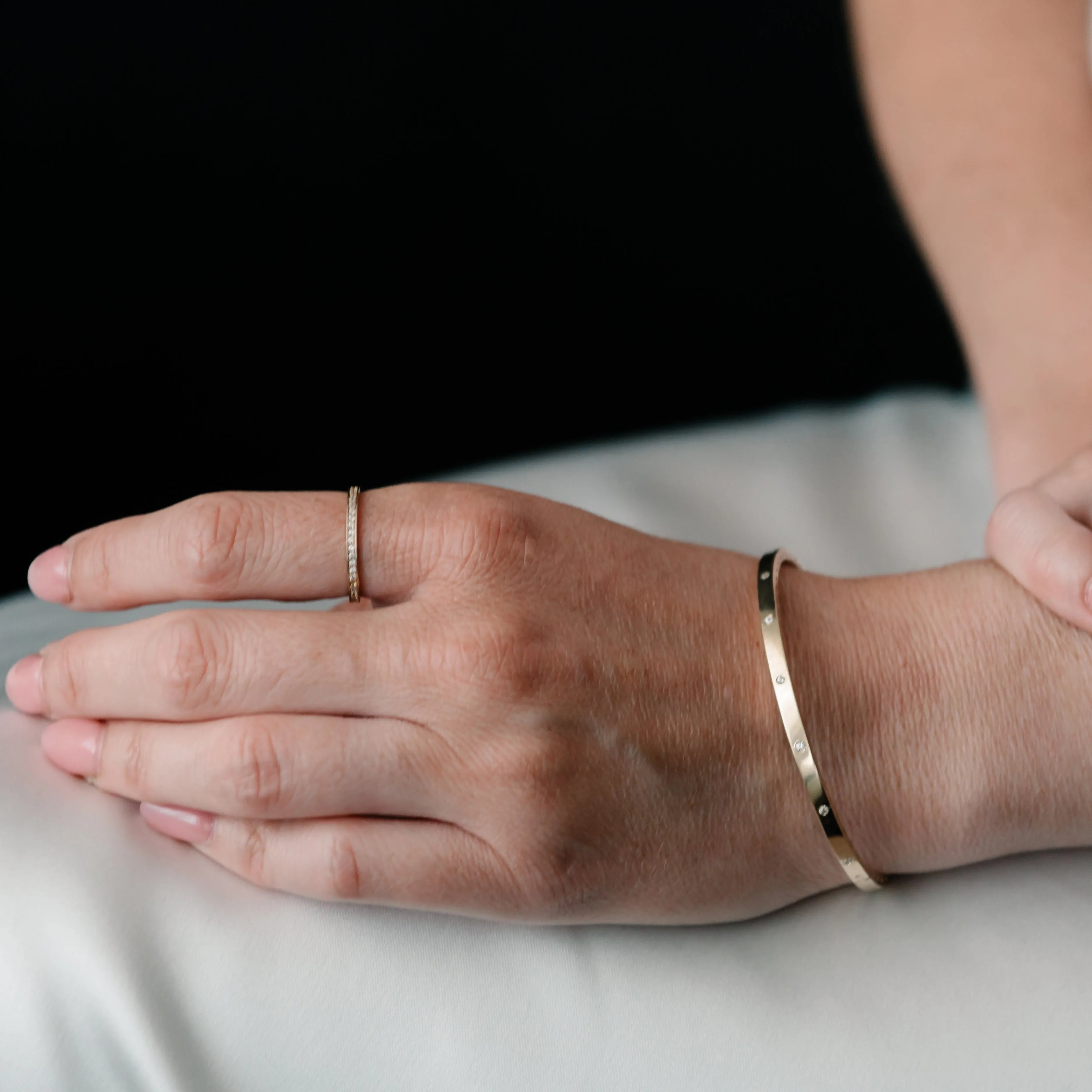 Zlatý bangle náramok CREYO STRUCTURA so zirkónmi na zápästí ženy