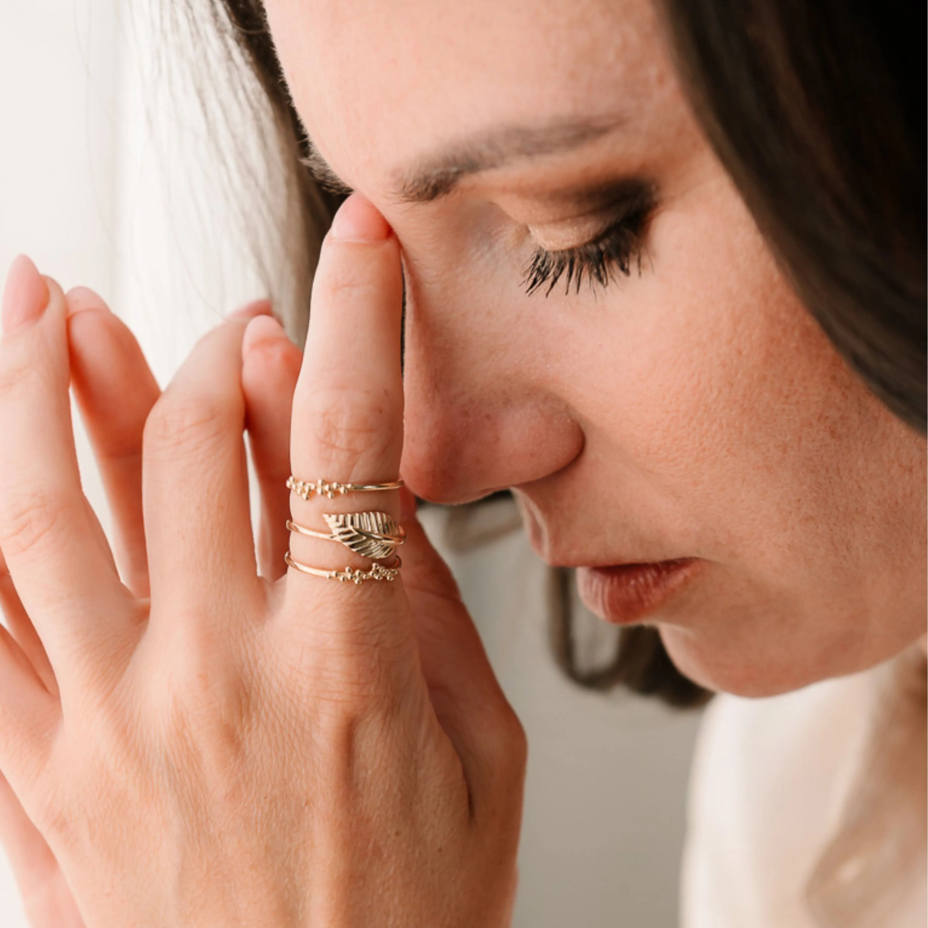 Žena nosí niekoľko zlatých prsteňov, vrátane dizajnu s guľôčkami – CREYO DOTS