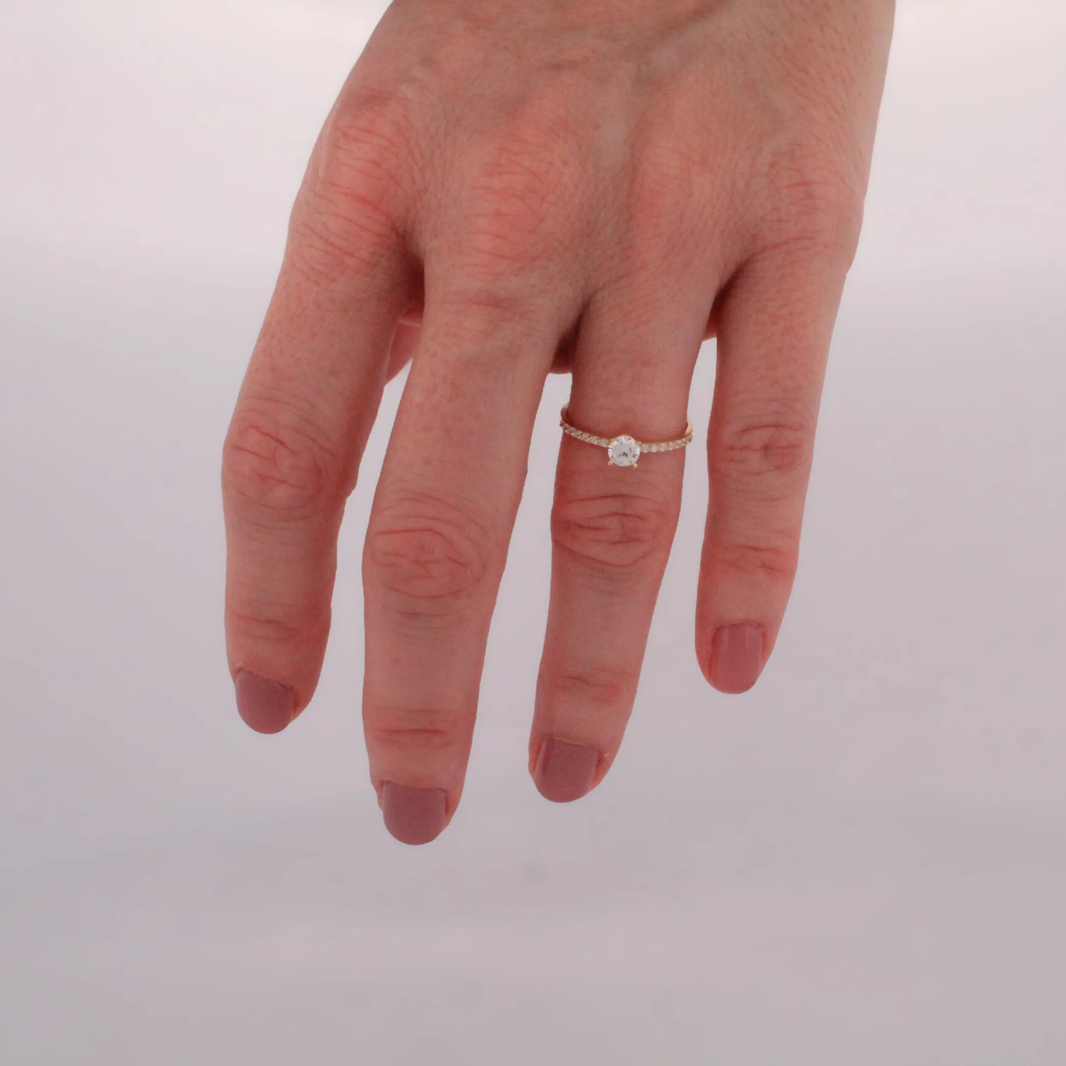 Elegantný prsteň STELLA zo žltého zlata so zirkónom v minimalistickom pozadí.