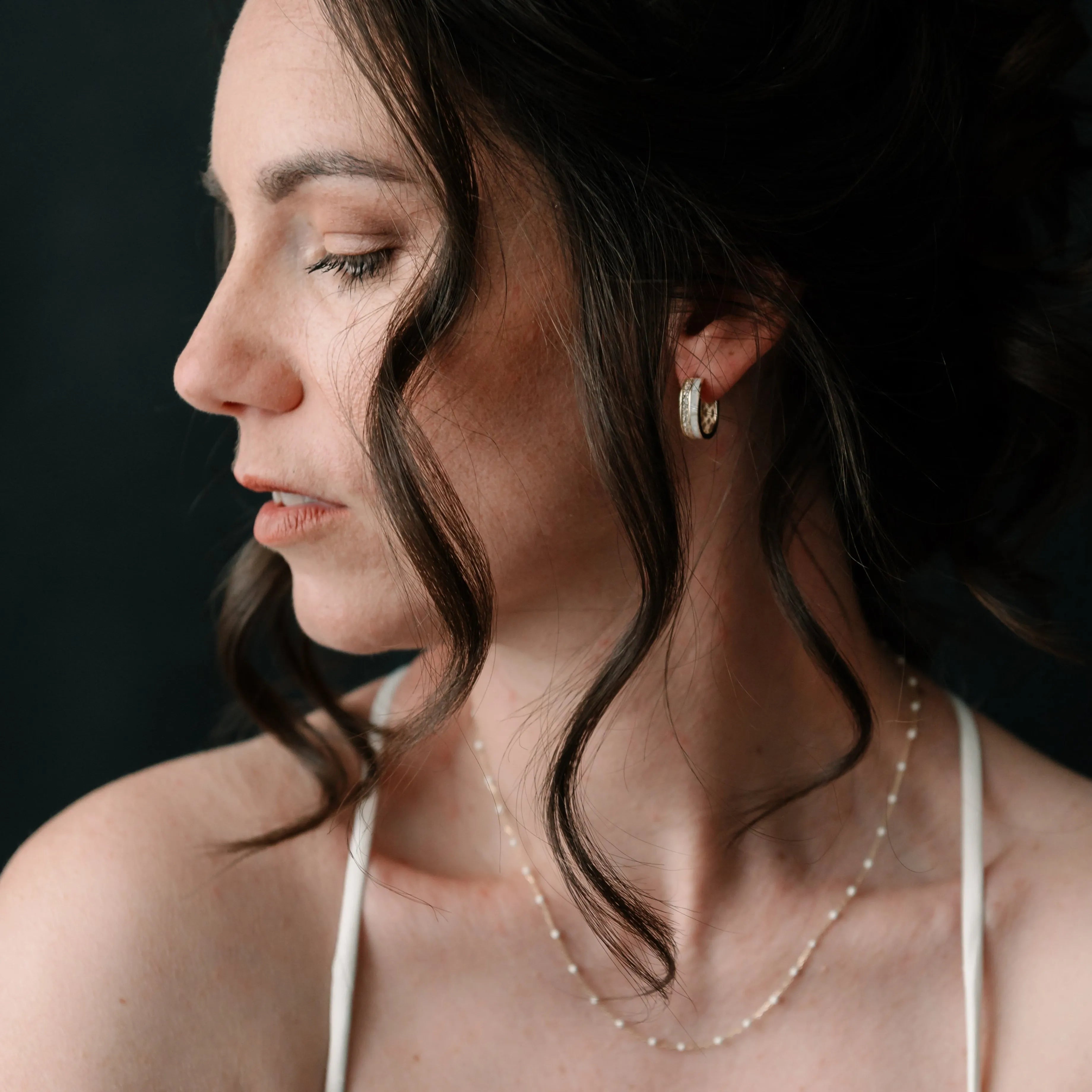 Vrstvený zlatý náhrdelník PUREA na žene s romantickým účesom