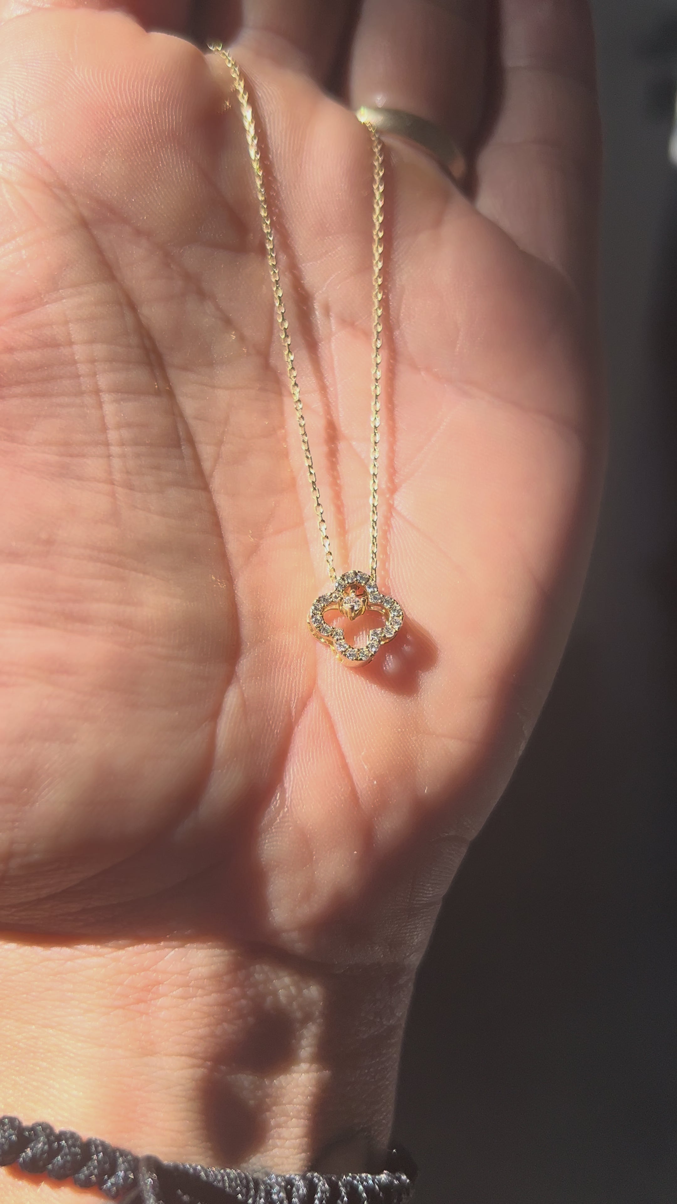 Video zobrazuje zlatý náhrdelník CREYO FLORÉ zo 14K žltého zlata s príveskom štvorlístka zdobeným kubickými zirkónmi. Detailné zábery ukazujú lesklú retiazku, precízne brúsené kamene a romantický dizajn vhodný na každodenné nosenie aj ako elegantný darček.