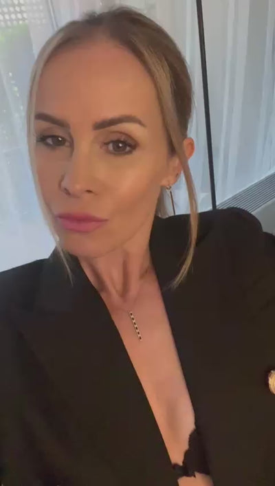 Video detailne zobrazuje visiace náušnice CREYO NOIR zo 14K žltého zlata s čiernym smaltovaným prvkom. Zábery ukazujú štíhly moderný dizajn s dĺžkou 4,5 cm, jemné línie zlata a kontrastný čierny akcent, ktorý zvýrazňuje luxusný a elegantný štýl náušníc.