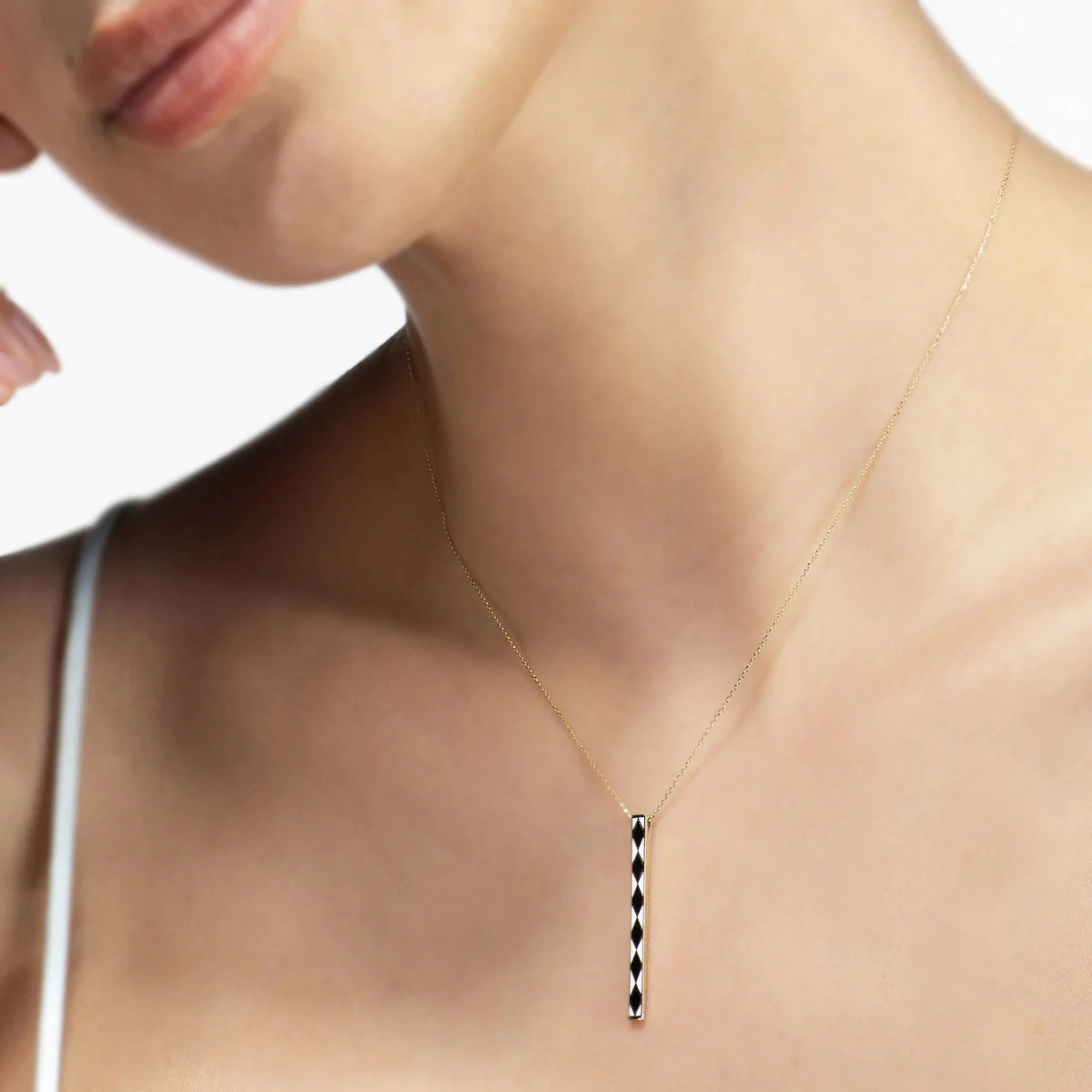 Detail zlatého náhrdelníka CREYO NOIR so vzorom na modelkinom krku